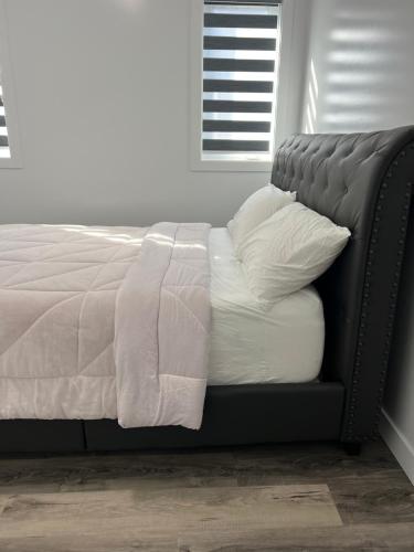 温尼伯Peniel Apartments的卧室内的一张带白色床单和枕头的床