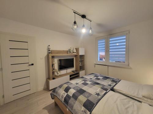 格丁尼亚Apartament Nad Klifem SEA VIEW的一间卧室设有一张床、一台电视和一个窗口。