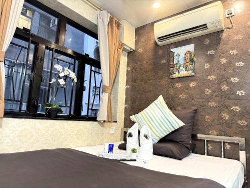 香港New International Guest House的一间卧室配有一张床,窗户配有空调