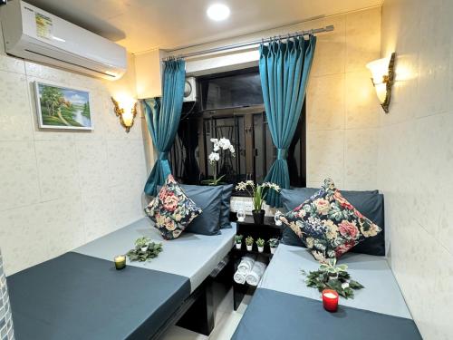 香港New International Guest House的客房设有2张蓝色的沙发和1扇窗户。