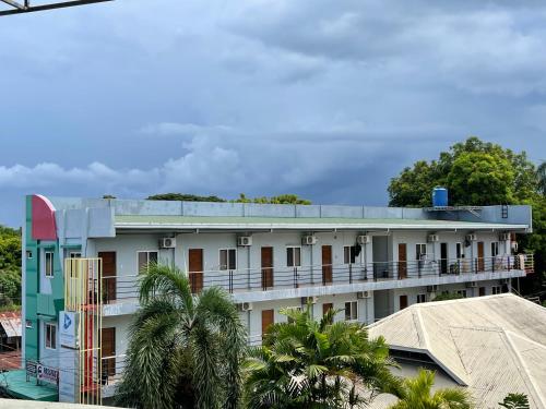 杜马格特Japandi-inspired Hideaway的白色的建筑,有蓝色的屋顶和棕榈树