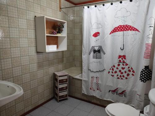 PutemúnHospedaje Martita.的浴室设有淋浴帘,配有带雨伞的女士