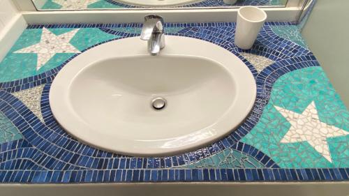 圣马丹德雷Appart à St Martin de Ré的浴室设有水槽,铺有蓝色和白色的瓷砖