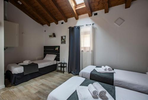 莱科La Casa del Sarto - Rooms and Apartments的带三张床和窗户的客房