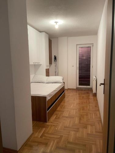 Kosovo PoljeErion’s apartament的一间卧室配有一张床,铺有木地板
