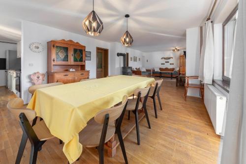 博希尼科尔斯尼克度假屋的用餐室配有黄色的桌子和椅子