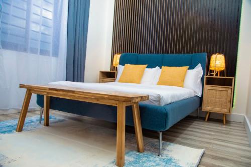 KiraBeHomu Apartments的一间卧室配有蓝色的沙发和一张桌子