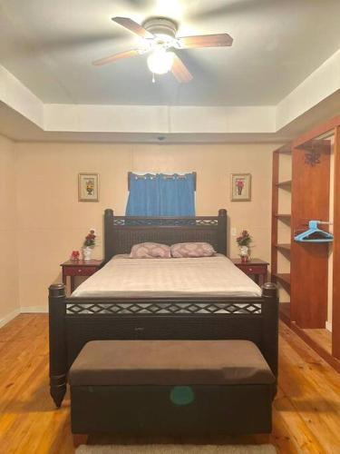 罗阿坦Island style home, low key rental的一间卧室配有一张带吊扇的床