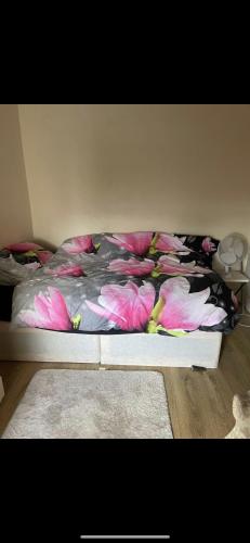 Enfield LockBeautiful Studio flat的卧室里一张带粉红色花的床铺