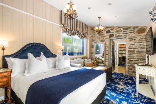 皇后镇Hulbert House Luxury Boutique Lodge Queenstown的一间卧室设有一张大床和石墙