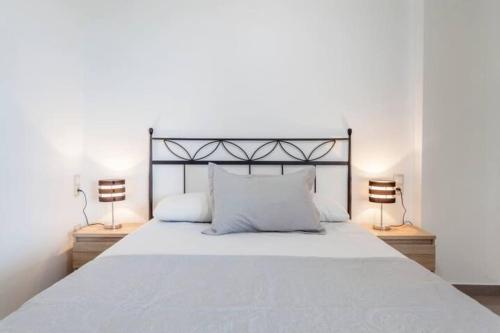瓦伦西亚Patacona Penthouse SeaView的一间卧室配有一张带两盏灯的大型白色床。