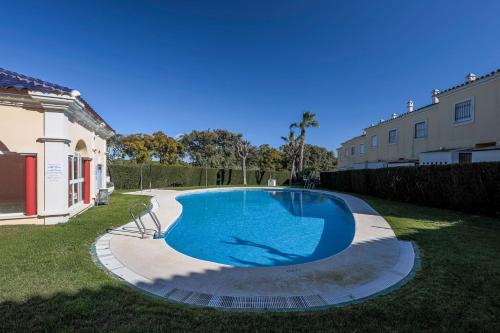 韦尔瓦Adosado Cigüeñas IV-Islantilla Golf的一座房子的院子内的大型游泳池