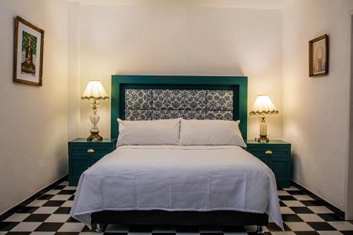 阿特利斯科Casa Zepeda的一间卧室配有一张带2个床头柜和2盏灯的床。