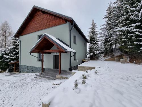 兹蒂尔Chata pod smrečkami s krbom a krásnym prostredím的前面的地面上积雪的房子