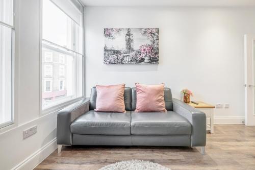 伦敦Bright & Modern 2-Bed Notting Hill Apartment的窗户客房内的灰色沙发
