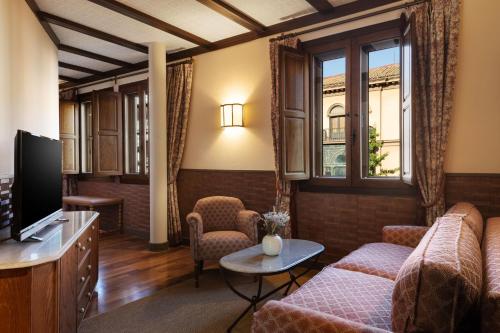 格拉纳达圣保拉宫傲途格精选酒店的带沙发和电视的客厅