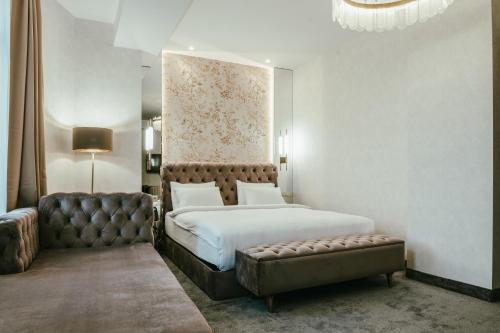 第比利斯Highgarden Hotel的一间卧室配有一张大床和一张沙发