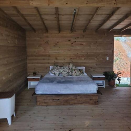卡利Kuyana Glamping的卧室配有木墙内的一张床