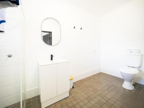 拜伦湾YHA Cape Byron, Byron Bay的白色的浴室设有卫生间和镜子