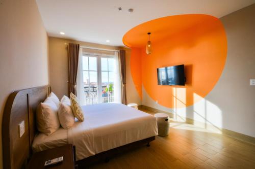 富国Aurora Phu Quoc Hotel & Cafe的卧室配有一张床,墙上配有电视。