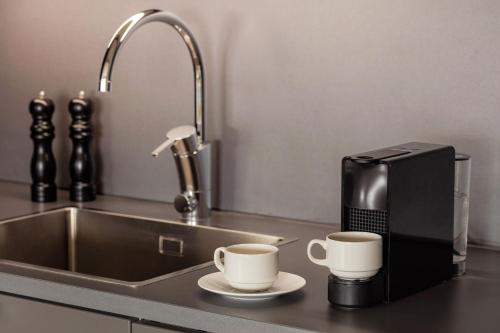 斯德哥尔摩斯德哥尔摩喜来登酒店的水槽旁厨房柜台上的两个咖啡杯