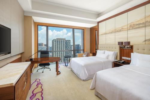 武汉武汉富力威斯汀酒店的酒店客房设有两张床和一台平面电视。