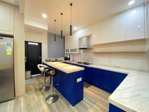 北赖Modern Cozy House 4Room10pax @Near Sunway Carnival的一间设有蓝色橱柜和柜台的大厨房
