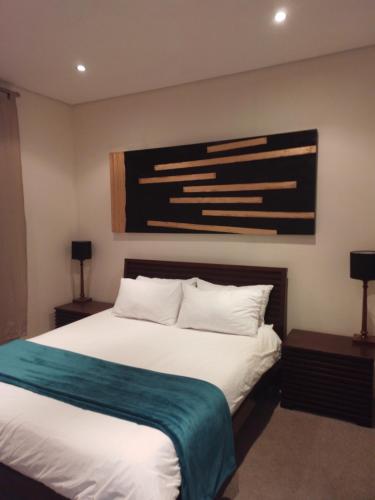 温特和克Business Pro Apartment, Windhoek的一间卧室配有一张白色的床和蓝色的毯子