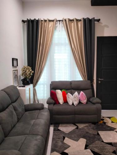 阿罗士打Asmar's Homestay Alor Setar的客厅配有带枕头的沙发
