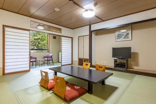 仙北龟之井酒店田泽湖的客厅配有桌椅和电视。
