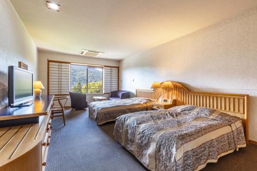 仙北龟之井酒店田泽湖的酒店客房设有两张床和一台平面电视。