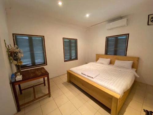 琅勃拉邦Mary’s Home Stay的卧室配有床、桌子和窗户。