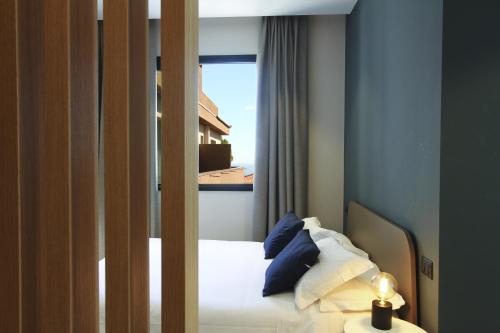 卡塔尼亚Ollen apartments的一间卧室配有一张蓝色墙壁的床和一扇窗户
