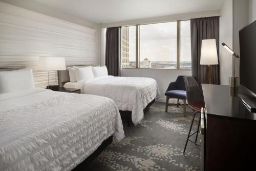 新奥尔良新奥尔良美丽殿酒店的酒店客房设有两张床和窗户。