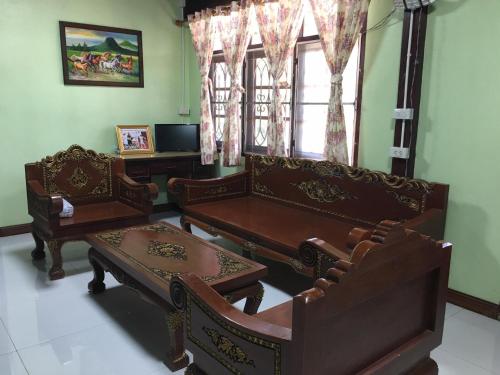 Ban Khlong Bang KhrokThe Orange House Thailand - Baan P'Nae Homestay的客厅配有椅子和桌子,设有窗户