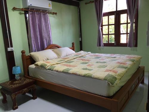Ban Khlong Bang KhrokThe Orange House Thailand - Baan P'Nae Homestay的一间卧室配有床,床上装有被子