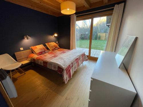 莱德萨阿尔卑斯Chalet le Lotus Blanc的一间卧室设有一张床和一个大窗户