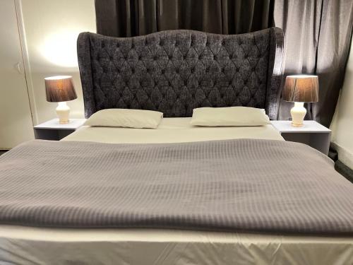 伊斯兰堡Two Bed Apartment F6 netflix wifi ac的一张大床,配有一个大床头板和两盏灯