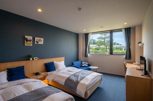 Tōna奥松島LANEホテル的酒店客房设有两张床和窗户。