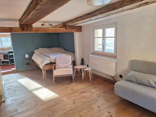布科Alte Schmiede Buckow的一间卧室配有一张床、一张桌子和一张沙发