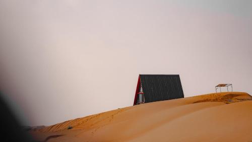 BadīyahMoon Light Camp的沙丘顶部的建筑物