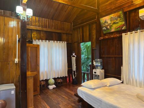 吉仙猫田河度假村的一间卧室设有两张床和木墙
