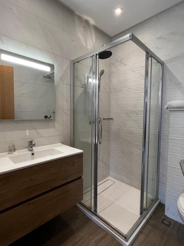 阿加迪尔Dominium Residence的一间带玻璃淋浴和水槽的浴室