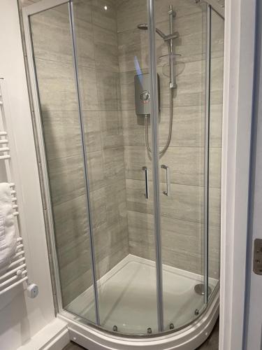 彼得伯勒Ascot House Apartments的浴室里设有玻璃门淋浴