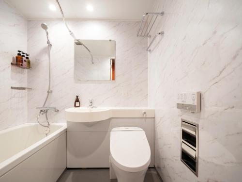 札幌the b sapporo的白色的浴室设有卫生间和水槽。