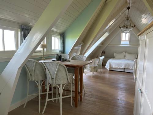 登乌弗Villa Nieuwland B&B的一间带桌椅和一张床的用餐室
