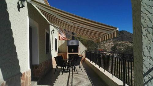 埃尔切德拉谢拉Casa Rural Puente Del Segura的阳台的天井配有桌椅