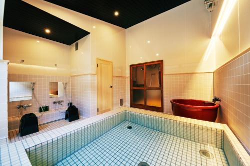 秩父市町住客室 秩父宿的大型浴室设有浴缸、卫生间和浴缸。