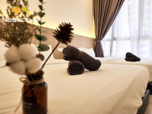 马六甲Mutiara Bali Residence Suites By Nestcove的泰迪熊躺在旅馆房间的床边