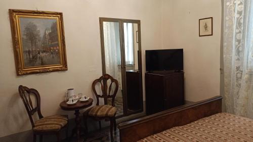 比萨Relais Corso Storico的一间卧室配有一张床、一台电视和一张桌子